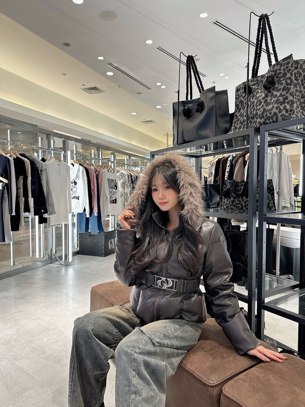 ブラック系のダウンジャケット/コート、ブラック系のブーツ、ブルー系のデニムパンツを着用したレディースの秋コーディネートの2枚目の写真