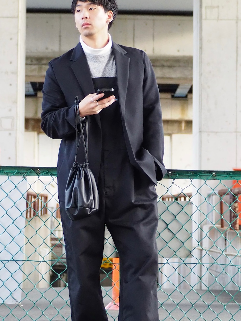 グレー系のニット/セーター、ブラック系のテーラードジャケット、ブラック系のショルダーバッグを着用したメンズの冬コーディネートの3枚目の写真