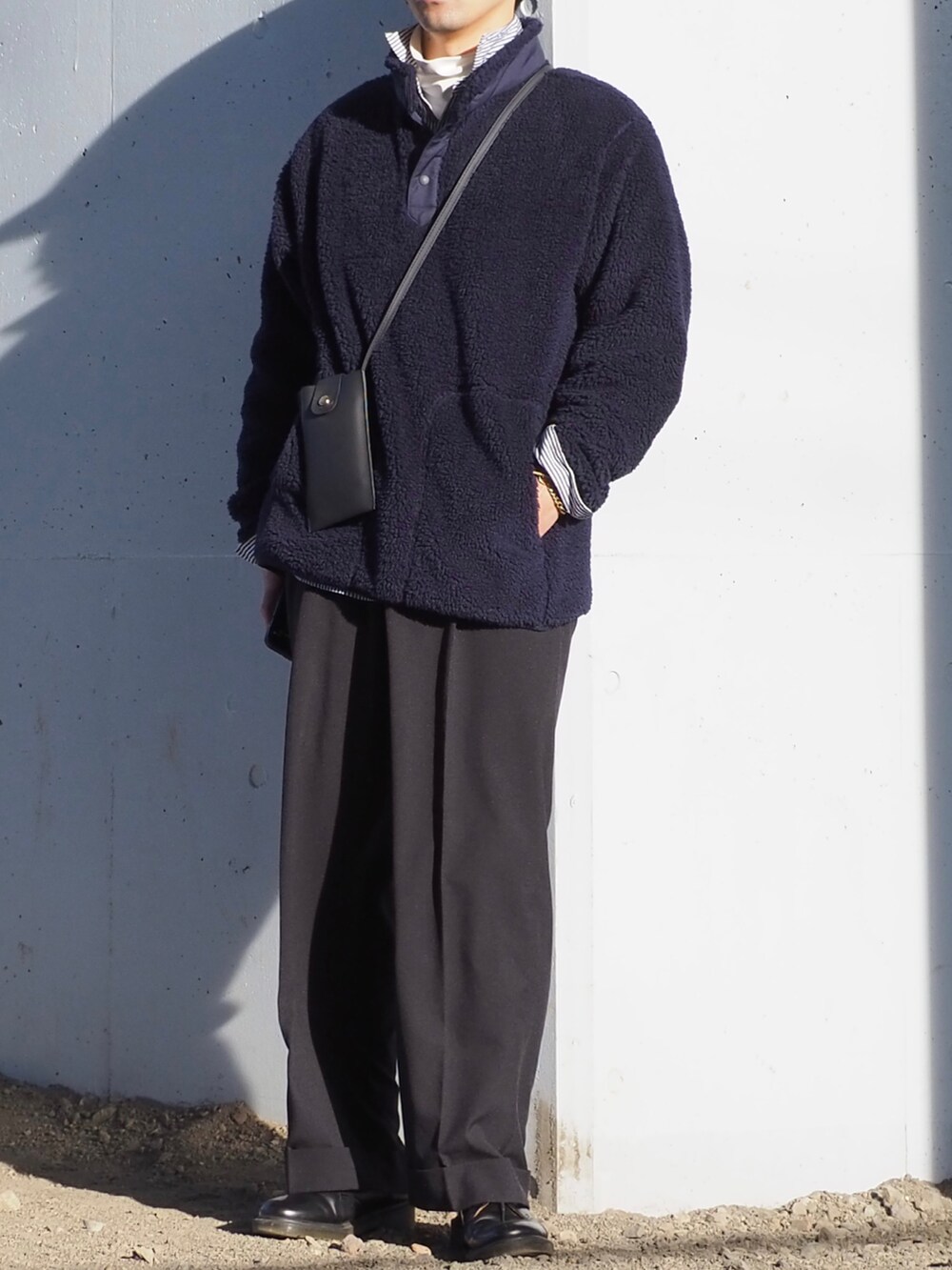 ホワイト系のTシャツ/カットソー、ブルー系のシャツ/ブラウス、ブラック系のスラックスを着用したメンズの冬コーディネートの4枚目の写真