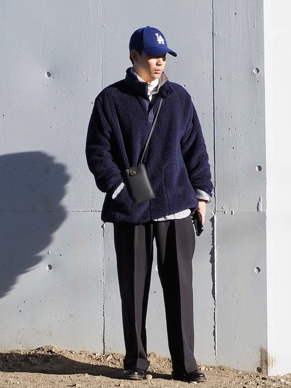 ホワイト系のTシャツ/カットソー、ブルー系のシャツ/ブラウス、ブラック系のスラックスを着用したメンズの冬コーディネートの2枚目の写真