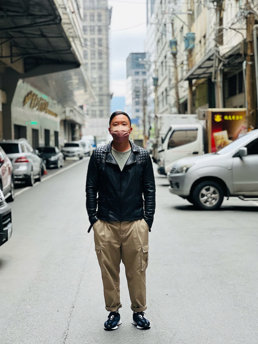 ブラック系のジャケット/アウター、ベージュ系のチノパンツ、ブラック系のスニーカーを着用したメンズの冬コーディネートの2枚目の写真