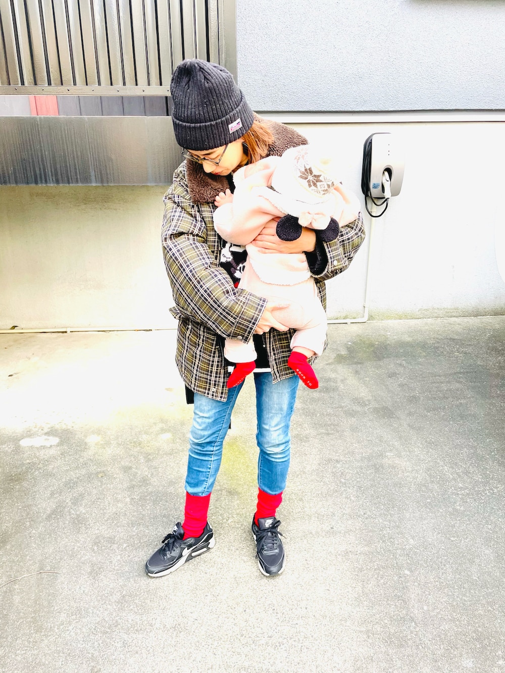 ブルー系のデニムパンツ、グリーン系のブルゾン、ブラック系のスニーカーを着用したレディースの冬コーディネートの2枚目の写真