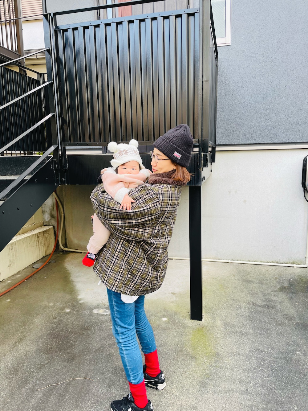 ブルー系のデニムパンツ、グリーン系のブルゾン、ブラック系のスニーカーを着用したレディースの冬コーディネートの3枚目の写真