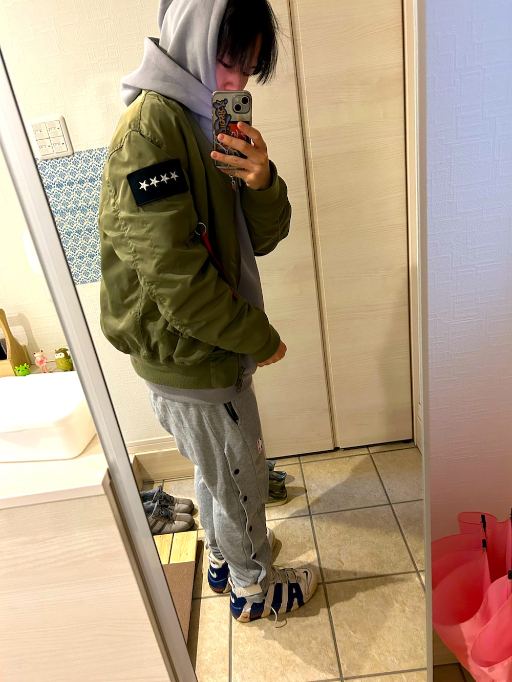 グレー系のパーカー、グリーン系のMA-1、グレー系のスウェットパンツを着用したメンズの冬コーディネートの2枚目の写真