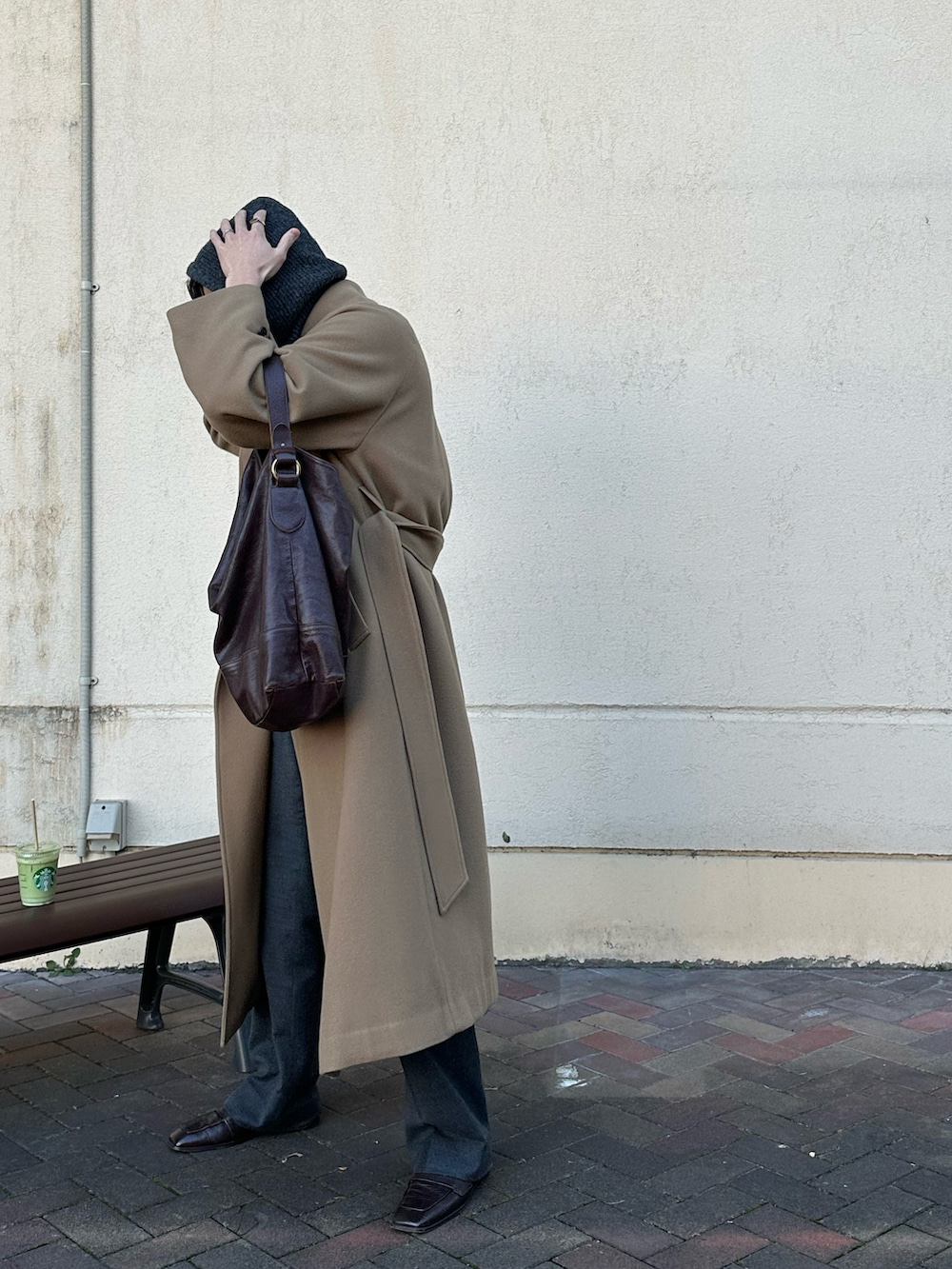 ブラウン系のニット/セーター、ブラウン系のバッグ、イエロー系のその他アウターを着用したメンズの冬コーディネートの2枚目の写真