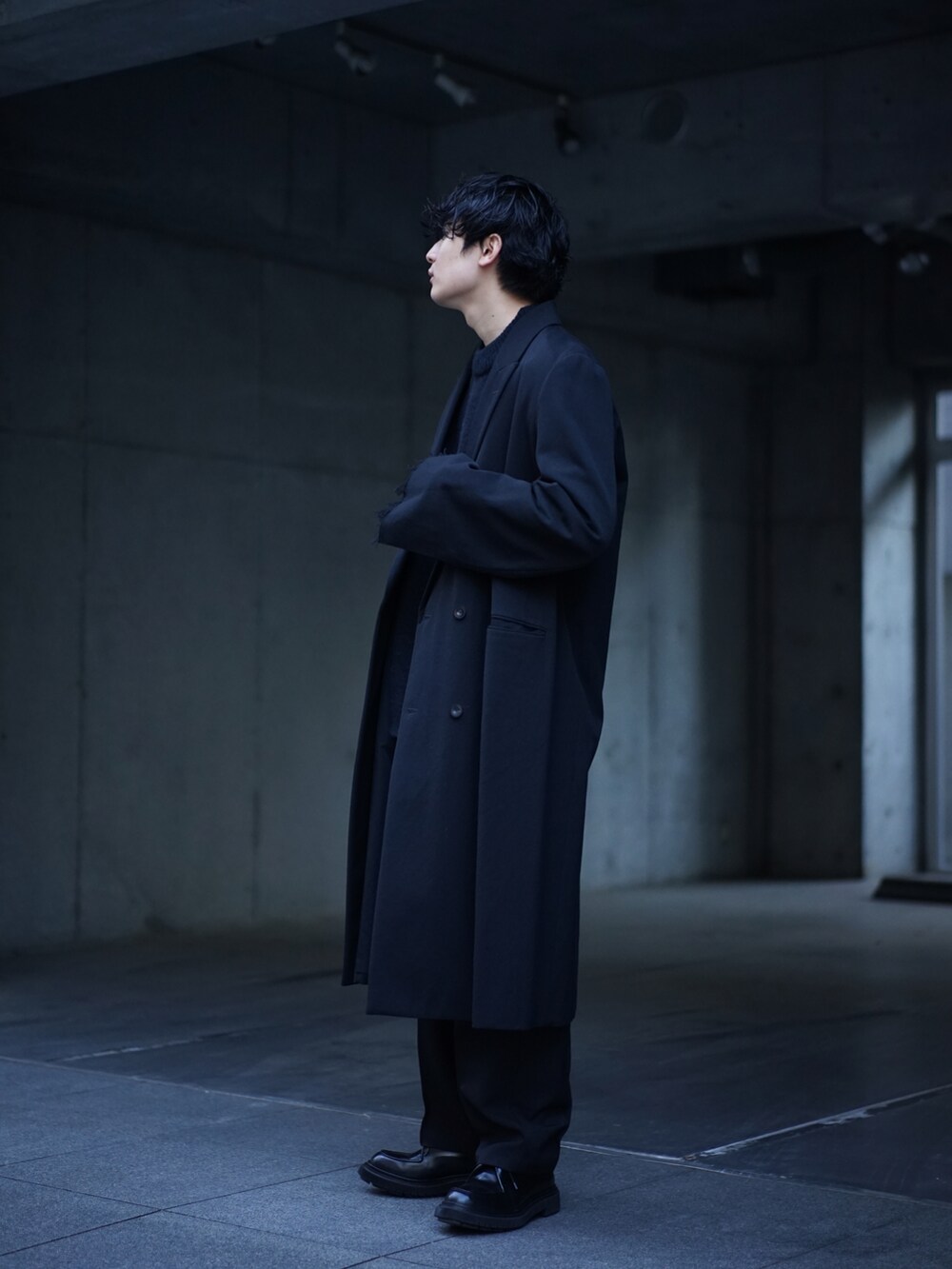 ブラック系のジャケット/アウター、ブラック系のニット/セーター、ブラック系のスラックスを着用したメンズの冬コーディネートの3枚目の写真