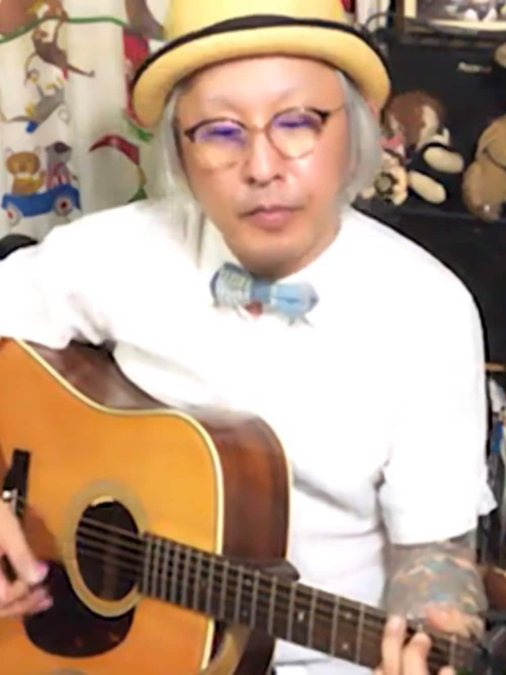 ブルー系の蝶ネクタイ、ブラック系のバングル/リストバンド、ベージュ系のハットを着用したメンズの夏コーディネートの2枚目の写真