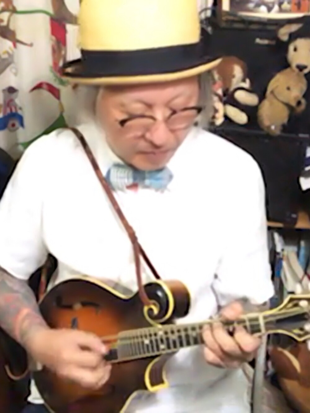 ブルー系の蝶ネクタイ、ブラック系のバングル/リストバンド、ベージュ系のハットを着用したメンズの夏コーディネートの3枚目の写真