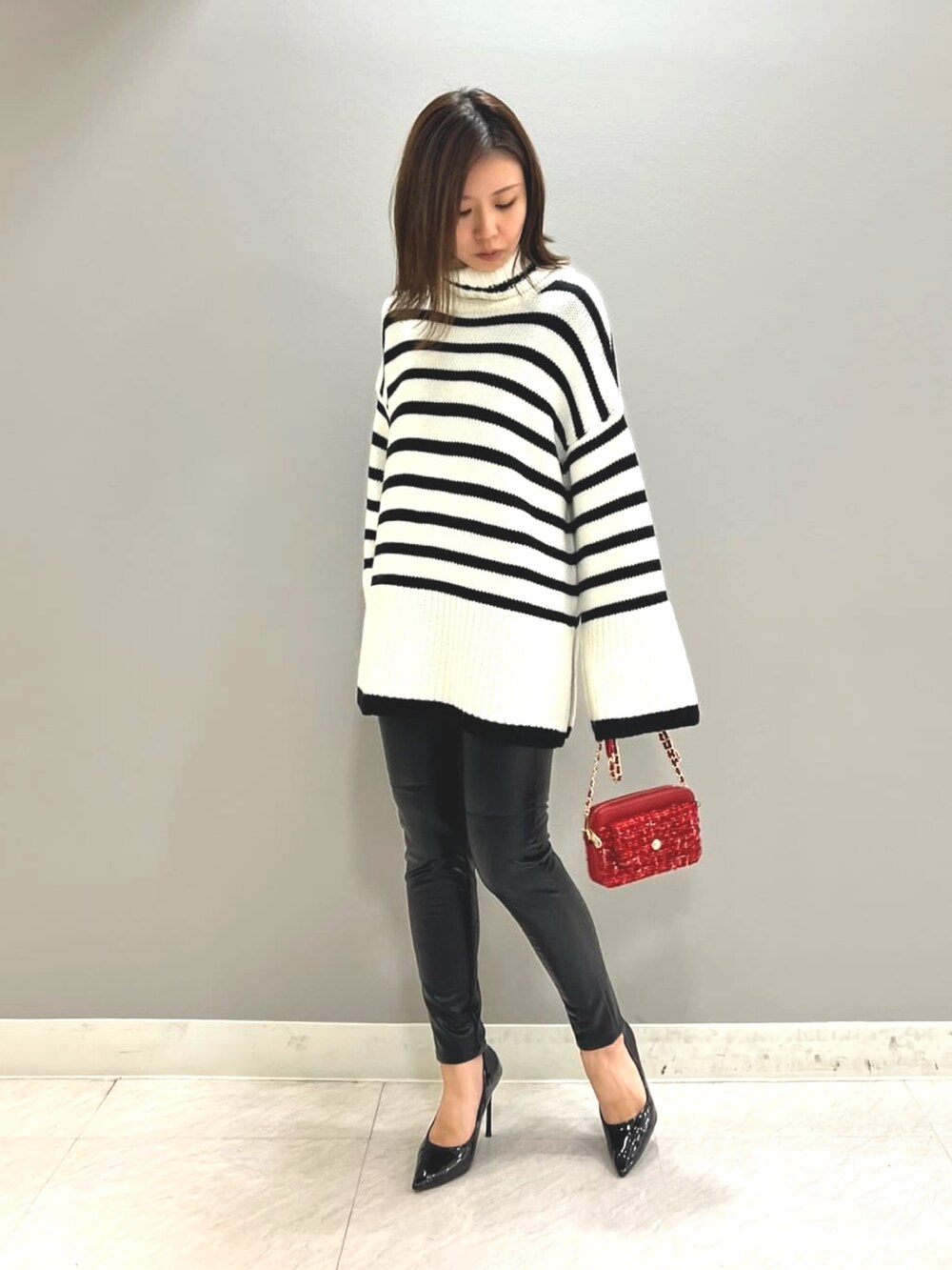 ブラック系のその他パンツ、レッド系のショルダーバッグ、ブラック系のニット/セーターを着用したレディースの秋コーディネートの2枚目の写真