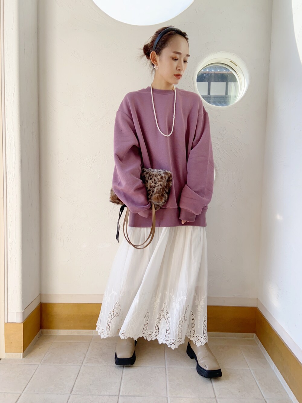 パープル系のスウェット、ベージュ系のブーツを着用したレディースの秋コーディネートの2枚目の写真