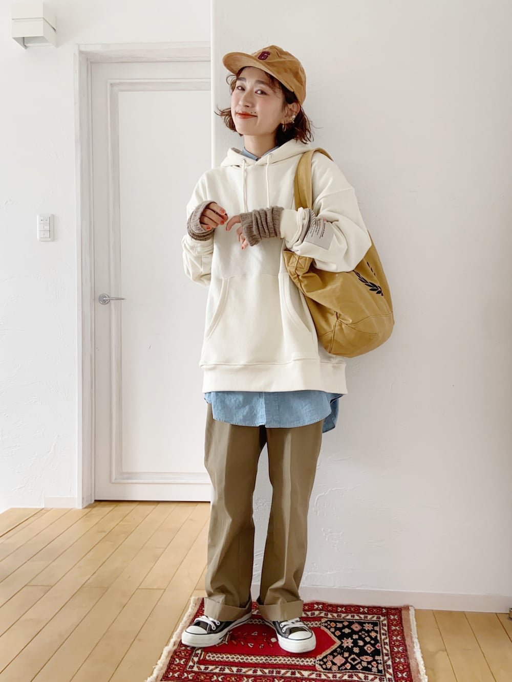 ホワイト系のパーカー、ベージュ系のチノパンツを着用したレディースの冬コーディネートの2枚目の写真