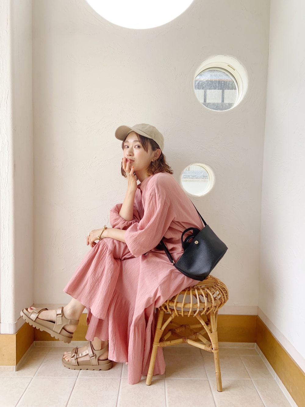 ベージュ系のサンダル、ピンク系のワンピース、ブラック系のトートバッグを着用したレディースの夏コーディネートの2枚目の写真