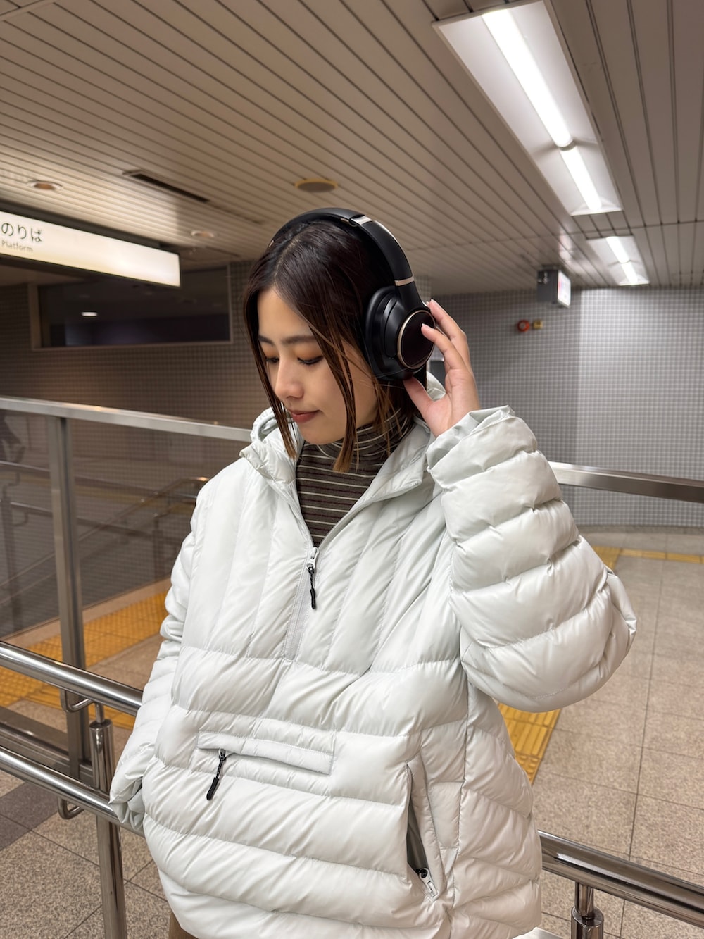 ブラウン系のTシャツ/カットソー、グレー系のダウンジャケット/コート、ブラウン系のデニムパンツを着用したレディースの冬コーディネートの2枚目の写真