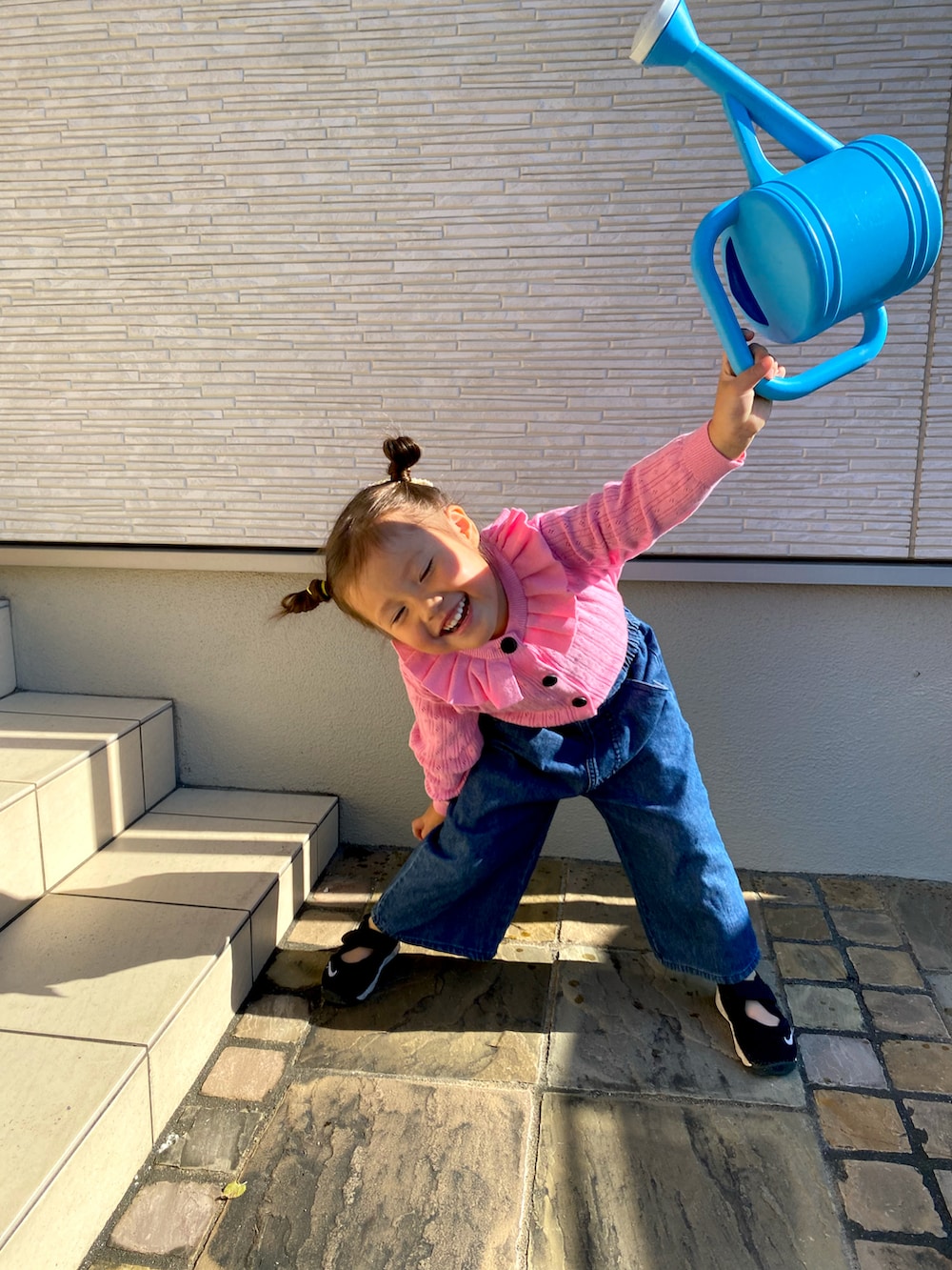 ピンク系のカーディガン/ボレロ、ブラック系のサンダルを着用したキッズの秋コーディネートの2枚目の写真