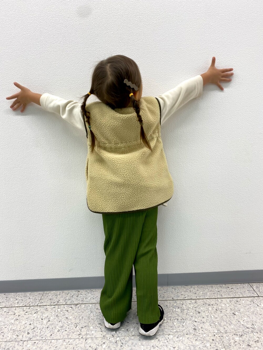 ベージュ系のベスト、グリーン系のその他パンツを着用したキッズの秋コーディネートの3枚目の写真