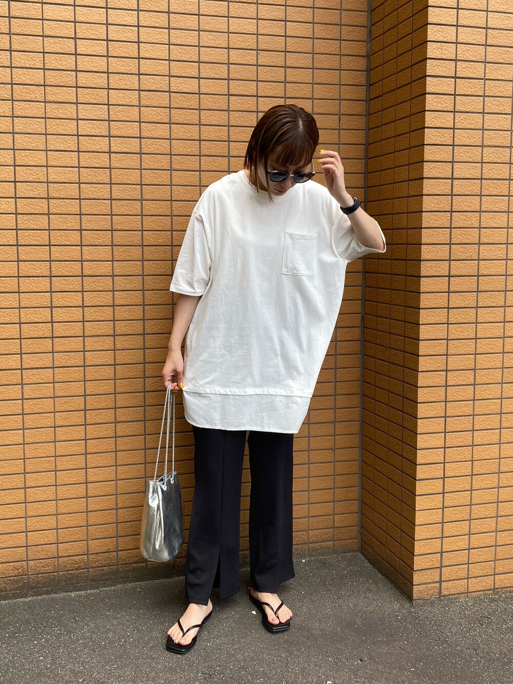 ブラック系のその他パンツ、ブラック系のサンダル、ホワイト系のTシャツ/カットソーを着用したレディースの春コーディネートの2枚目の写真