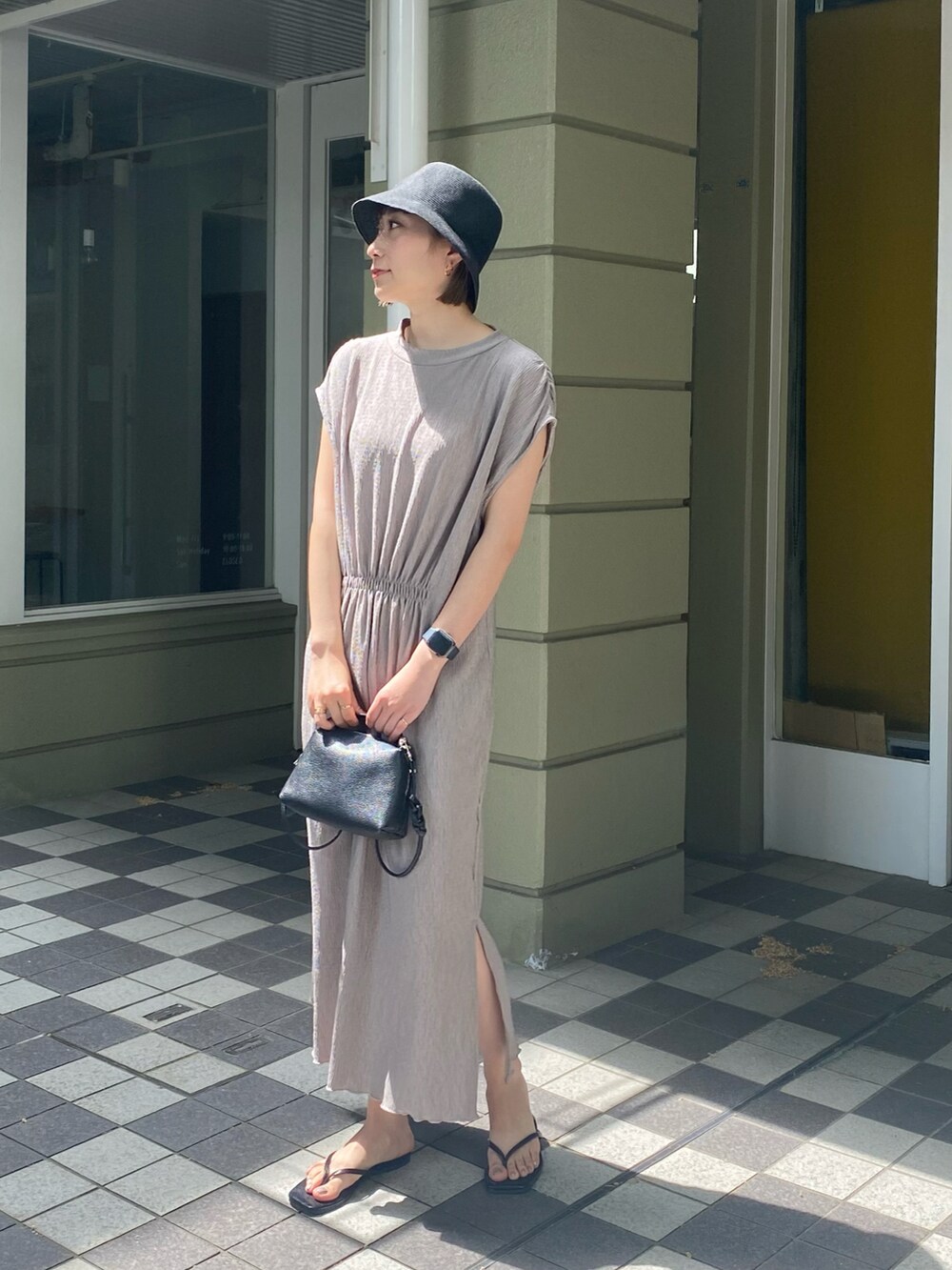 ブラック系のサンダル、ベージュ系のワンピースを着用したレディースの春コーディネートの2枚目の写真