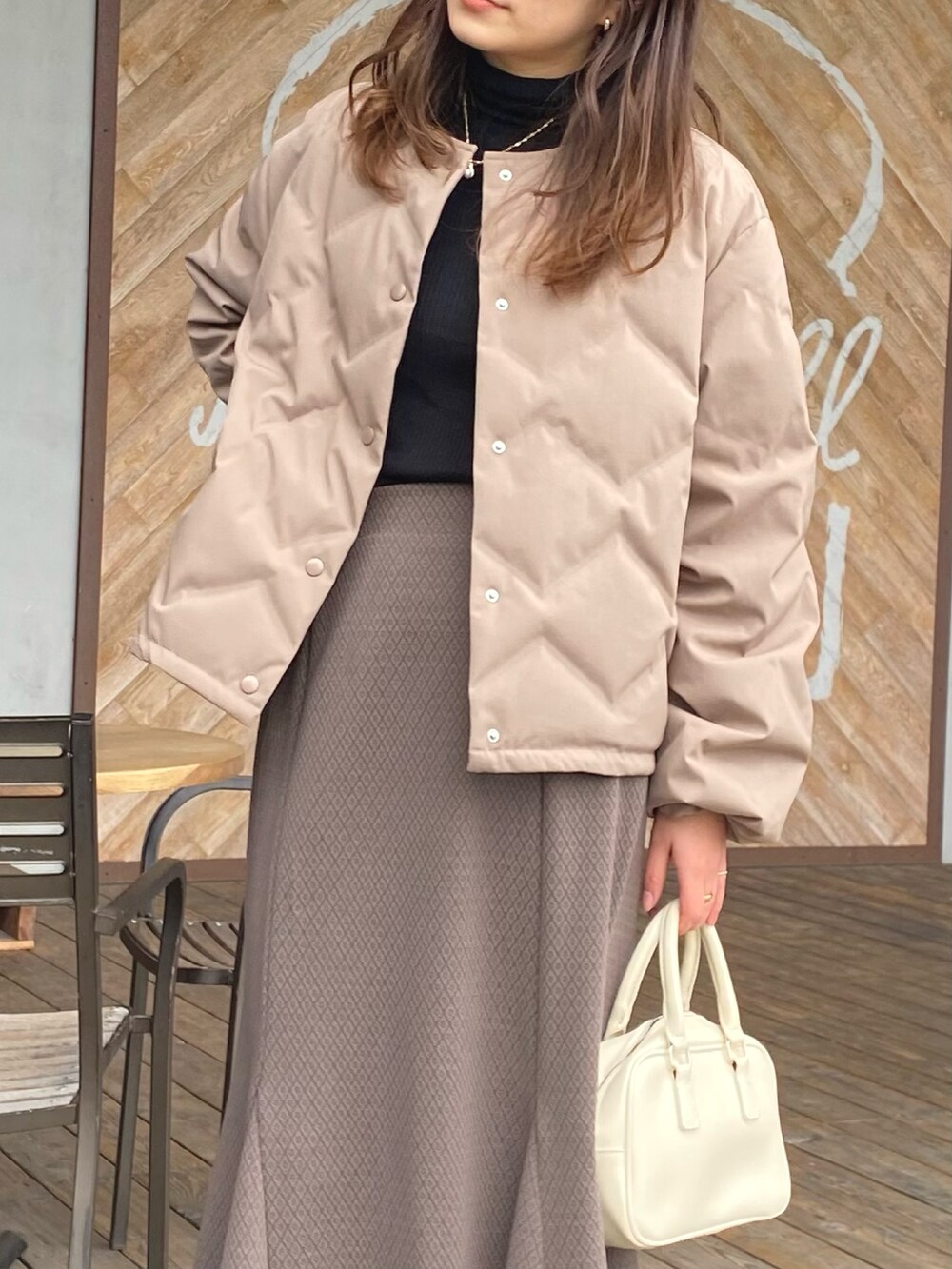 ブラウン系のダウンジャケット/コート、ブラウン系のスカートを着用したレディースの冬コーディネートの2枚目の写真