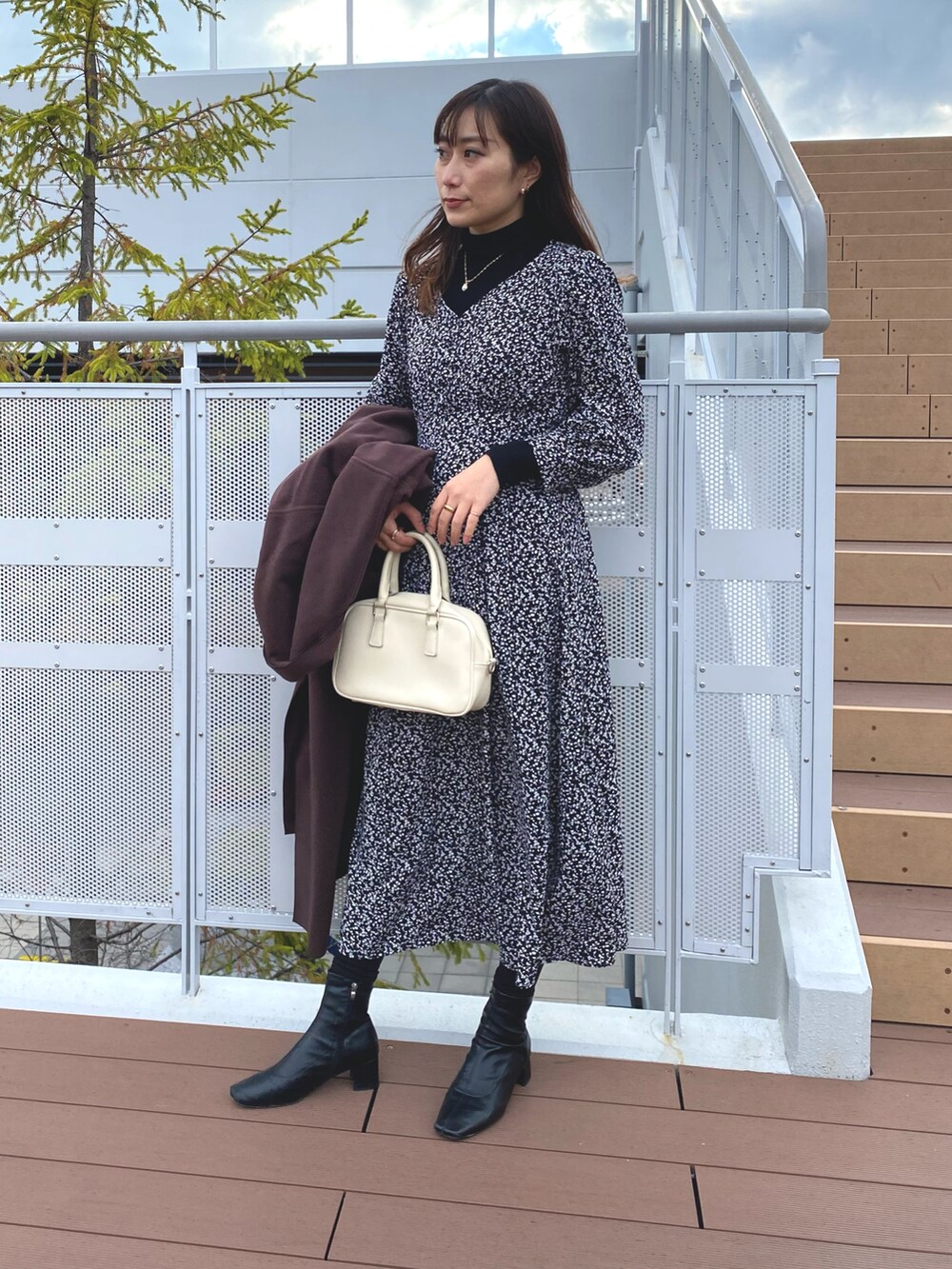 ブラック系のワンピースを着用したレディースの冬コーディネートの2枚目の写真