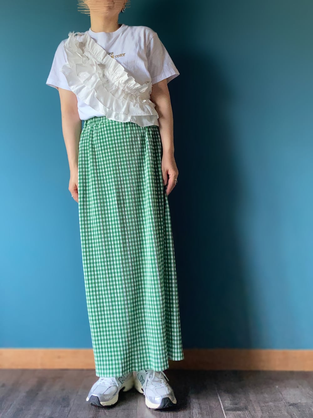 グリーン系のスカート、シルバー系のスニーカー、ホワイト系のTシャツ/カットソーを着用したレディースの夏コーディネートの2枚目の写真