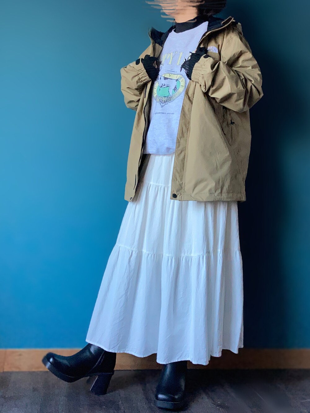 グレー系のスウェット、ホワイト系のサロペット/オーバーオール、ブラック系のアームカバーを着用したレディースの冬コーディネートの2枚目の写真