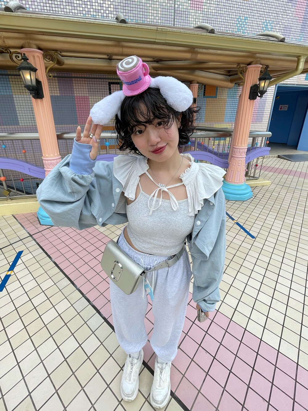 グレー系のスウェットパンツ、ホワイト系のスニーカー、シルバー系のショルダーバッグを着用したレディースの春コーディネートの4枚目の写真