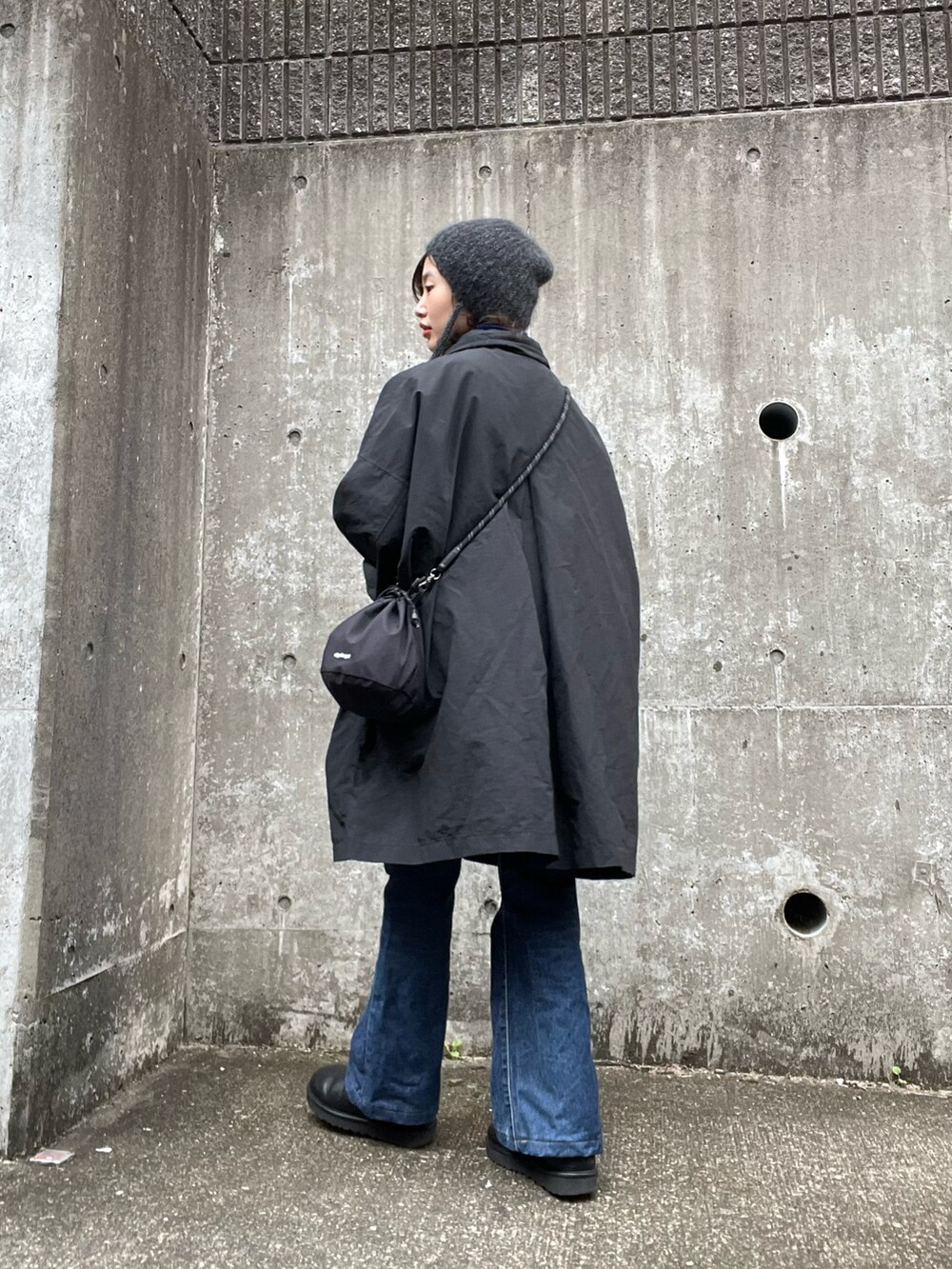 ブラック系のナイロンジャケット、ブラック系のショルダーバッグ、ブルー系のニット/セーターを着用したレディースの冬コーディネートの2枚目の写真