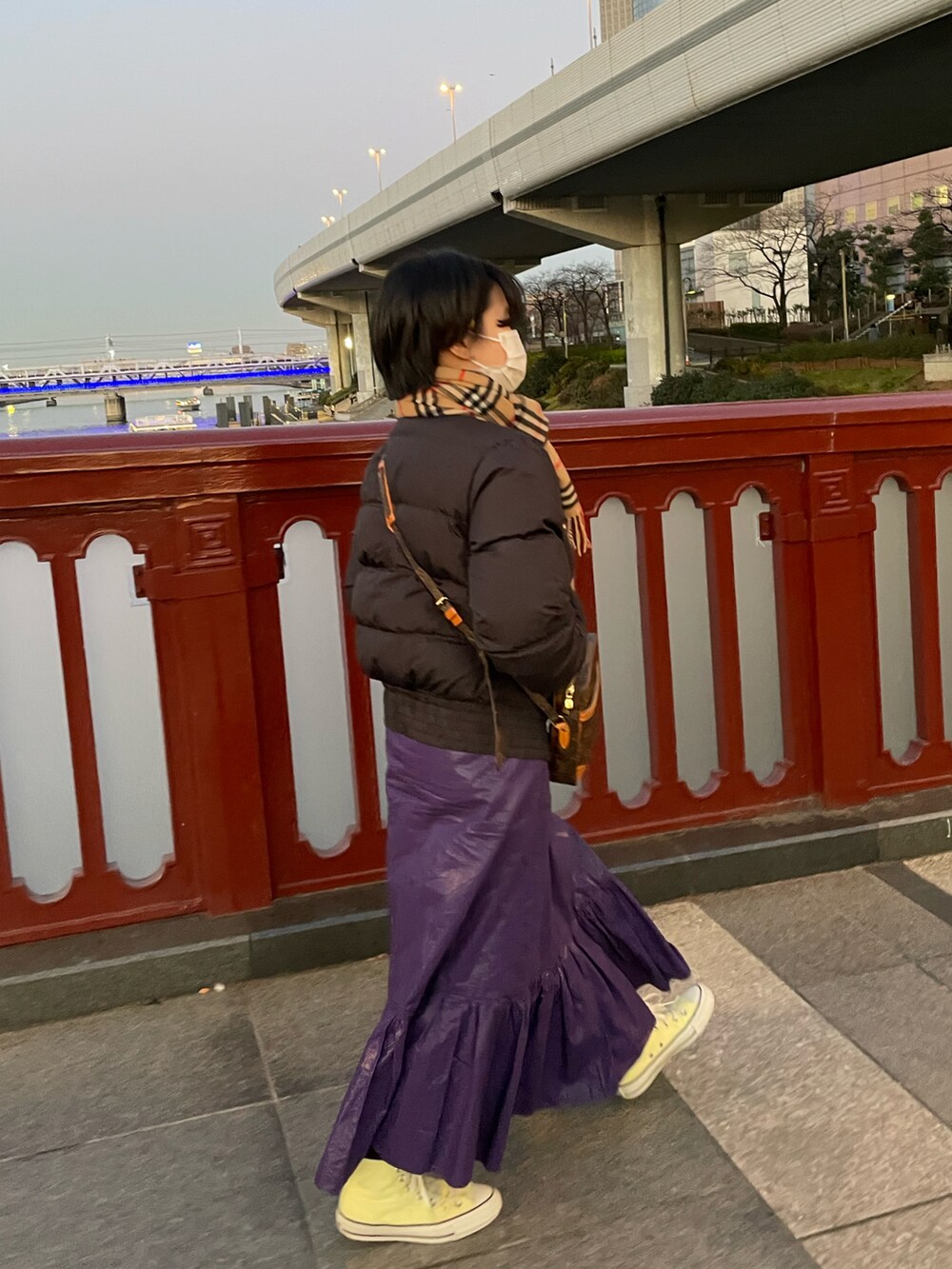 ブラック系のダウンジャケット/コート、パープル系のスカート、イエロー系のスニーカーを着用したレディースの冬コーディネートの2枚目の写真