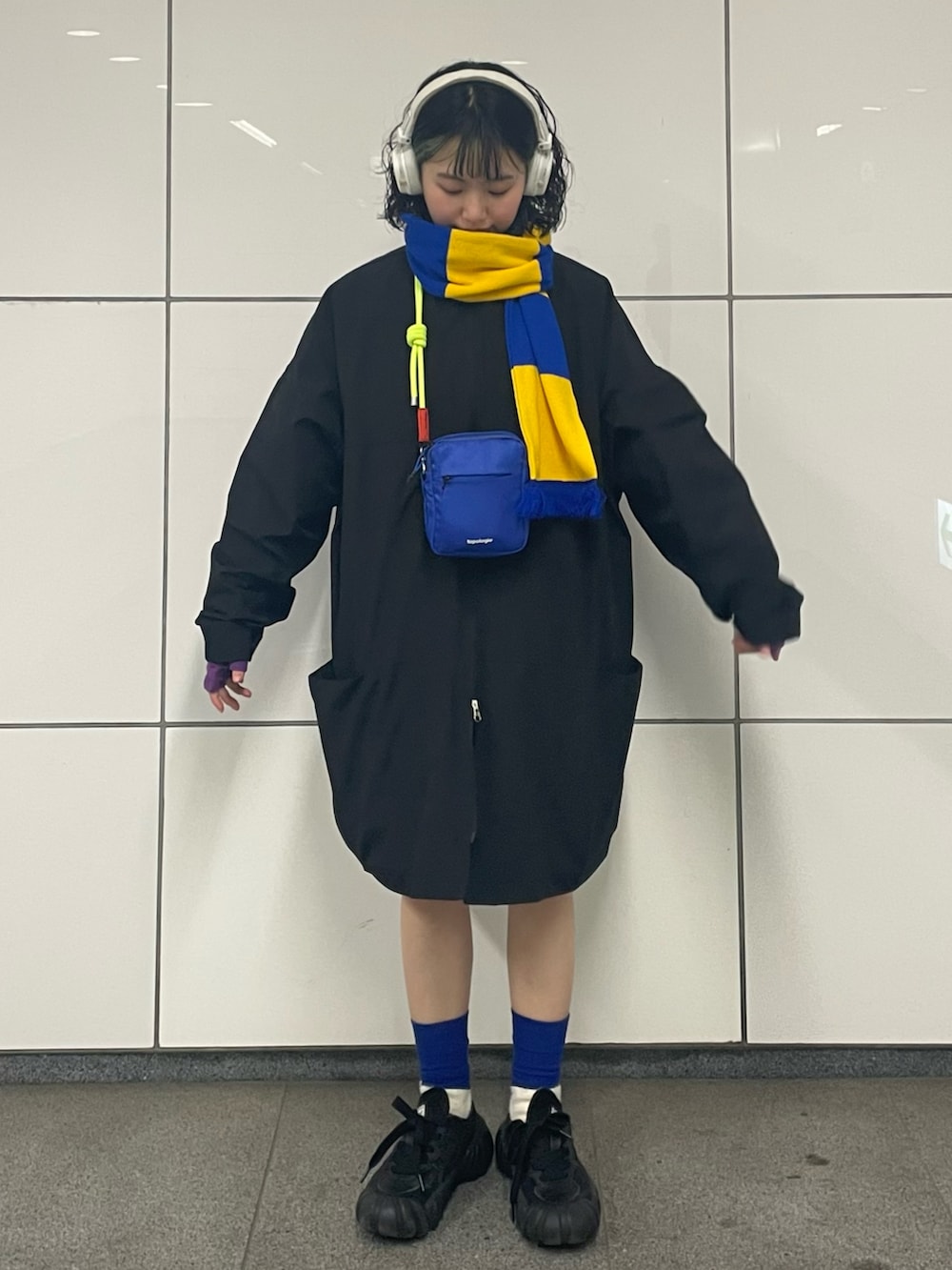 ブラック系のスニーカー、ブラック系のナイロンジャケット、ブルー系のショルダーバッグを着用したレディースの春コーディネートの2枚目の写真