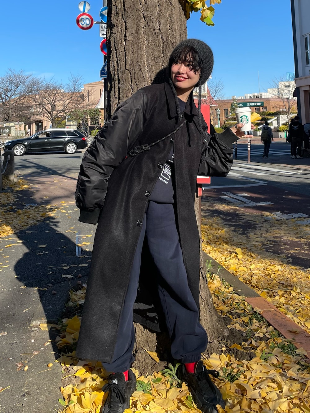 ブラック系のスニーカー、ブルー系のスウェットパンツ、ブラック系のその他アウターを着用したレディースの冬コーディネートの3枚目の写真