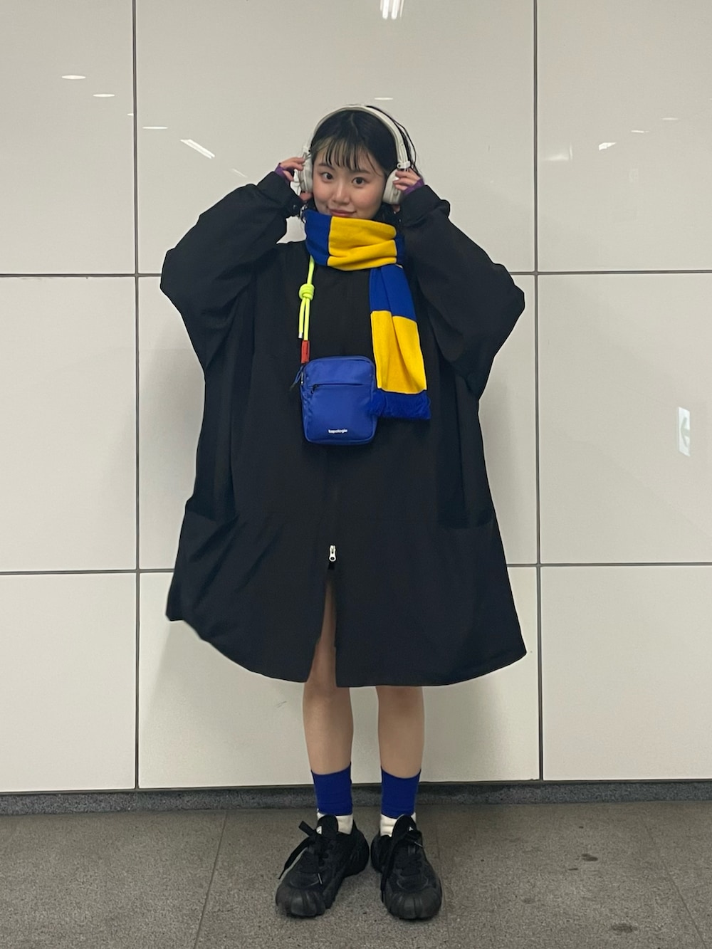 ブラック系のスニーカー、ブラック系のナイロンジャケット、ブルー系のショルダーバッグを着用したレディースの春コーディネートの3枚目の写真
