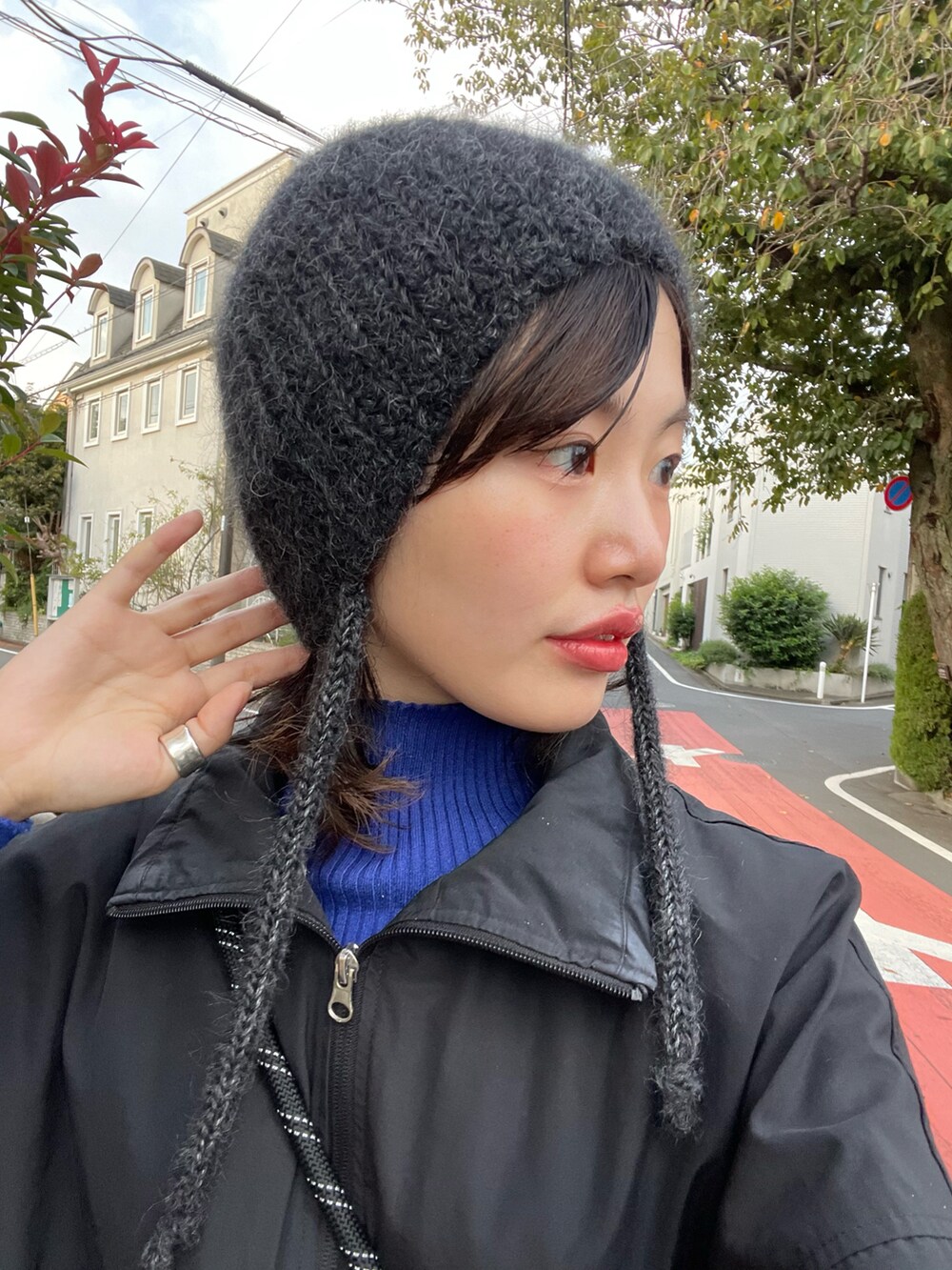 ブラック系のナイロンジャケット、ブラック系のショルダーバッグ、ブルー系のニット/セーターを着用したレディースの冬コーディネートの4枚目の写真