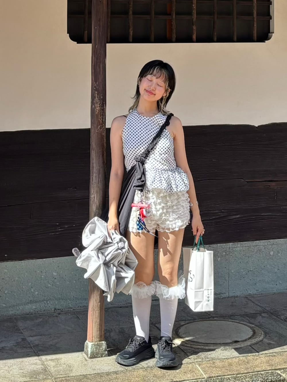 ブラック系のスニーカー、ホワイト系のシャツ/ブラウス、ホワイト系のその他パンツを着用したレディースの夏コーディネートの2枚目の写真