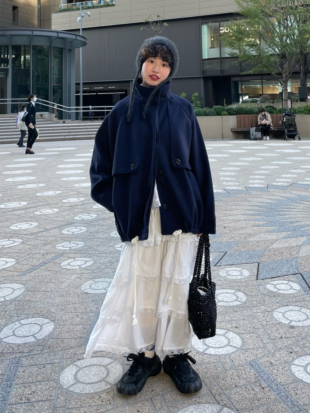 ブルー系のその他アウター、ホワイト系のスカート、ブラック系のスニーカーを着用したレディースの冬コーディネートの2枚目の写真