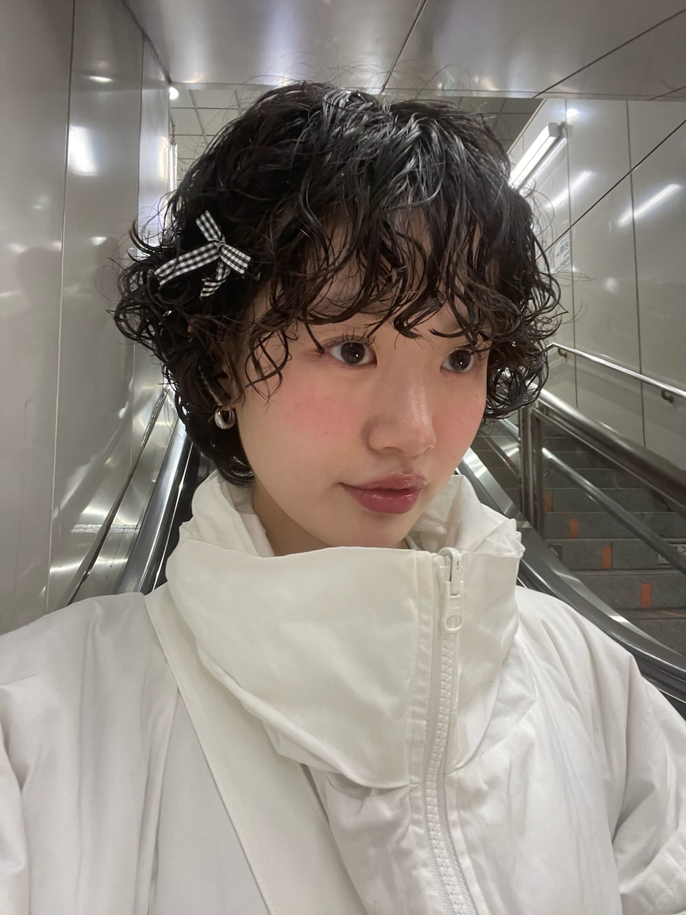 ベージュ系のスウェット、シルバー系のスカート、ブラック系のスニーカーを着用したレディースの冬コーディネートの3枚目の写真