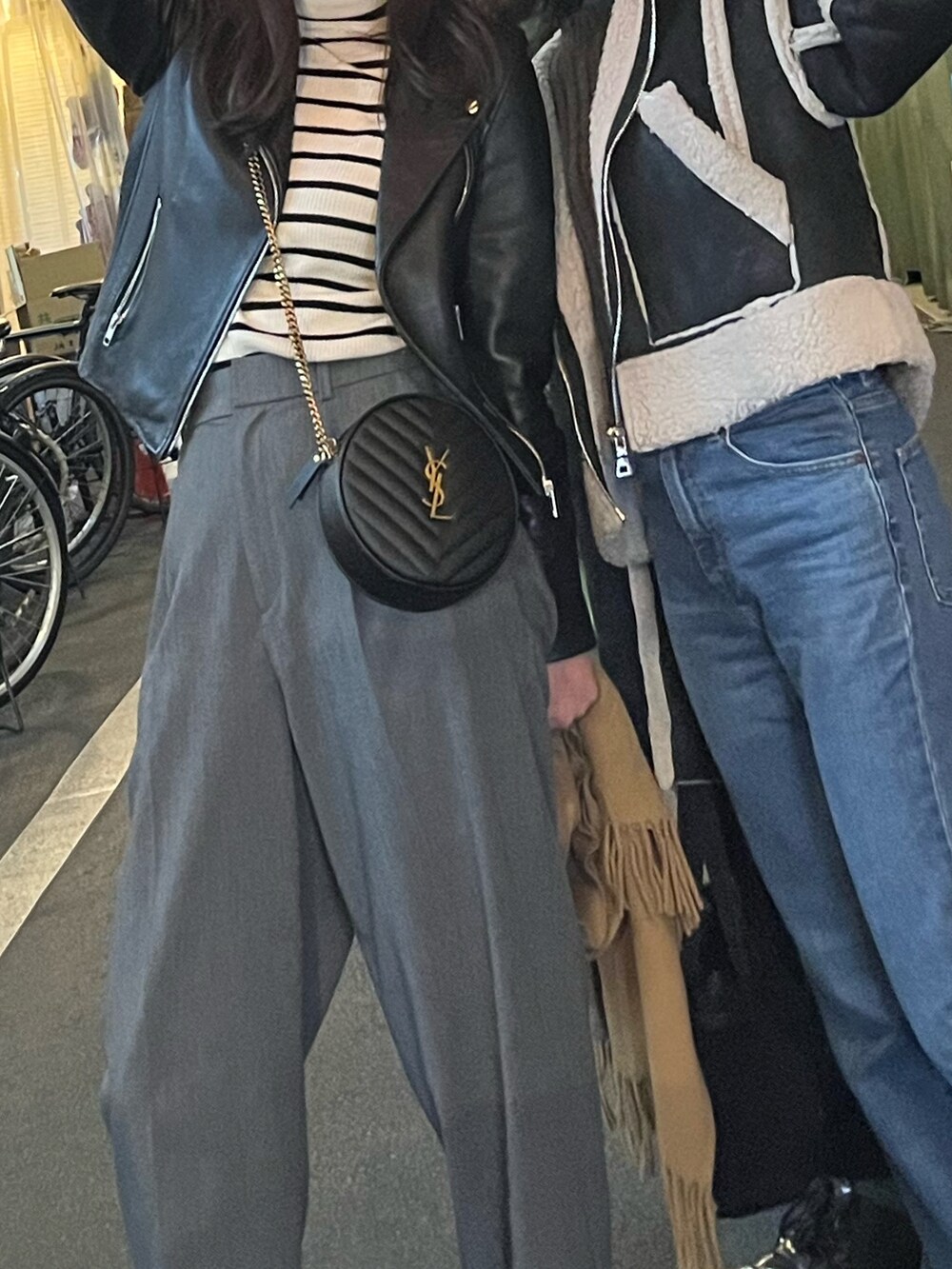 ブラック系のライダースジャケット、グレー系のスラックス、ホワイト系のブーツを着用したレディースの春コーディネートの2枚目の写真