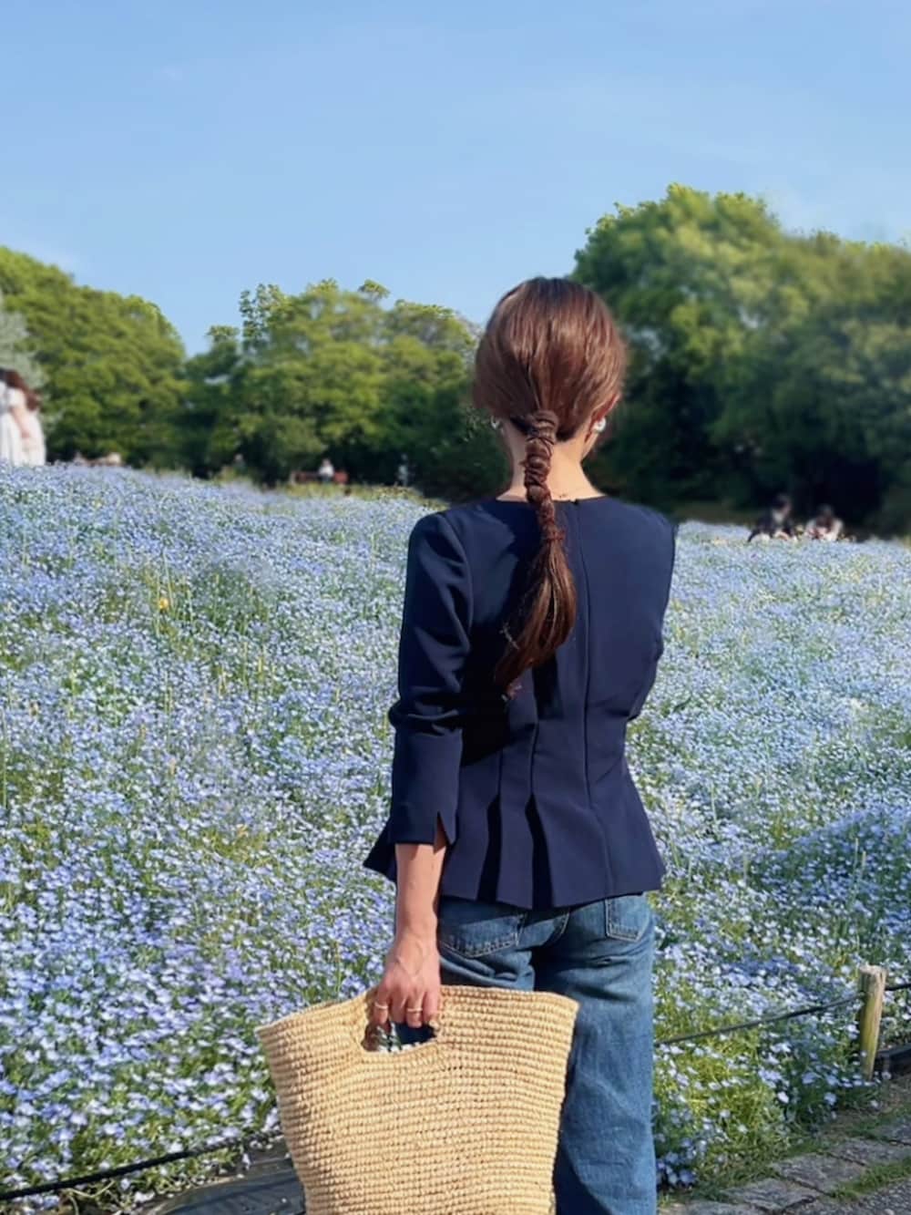 ブルー系のスーツセット、ベージュ系のかごバッグ、イエロー系のリングを着用したレディースの春コーディネートの2枚目の写真