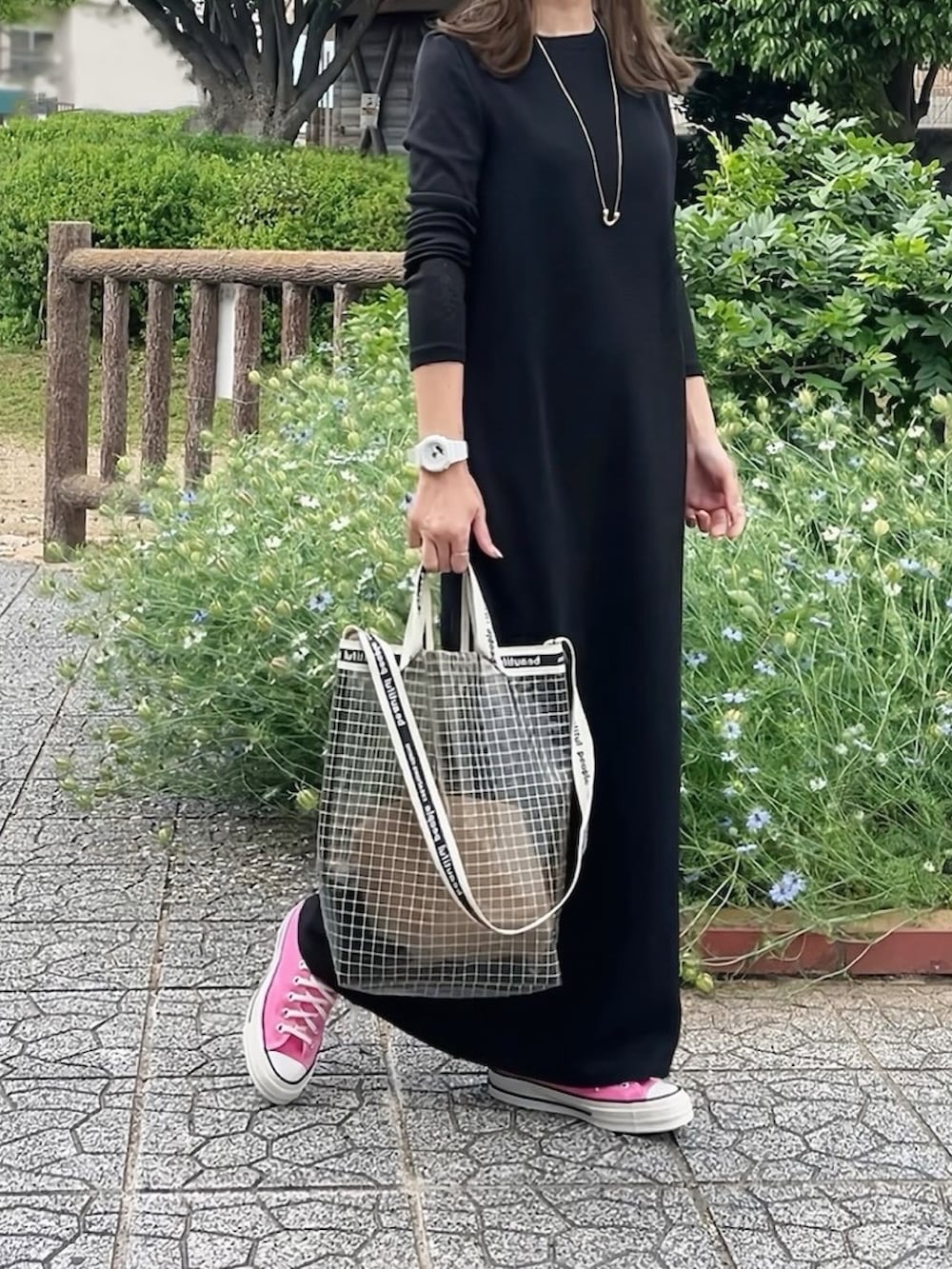 ブラック系のワンピース、ピンク系のスニーカー、ブラック系のハンドバッグを着用したレディースの夏コーディネートの2枚目の写真