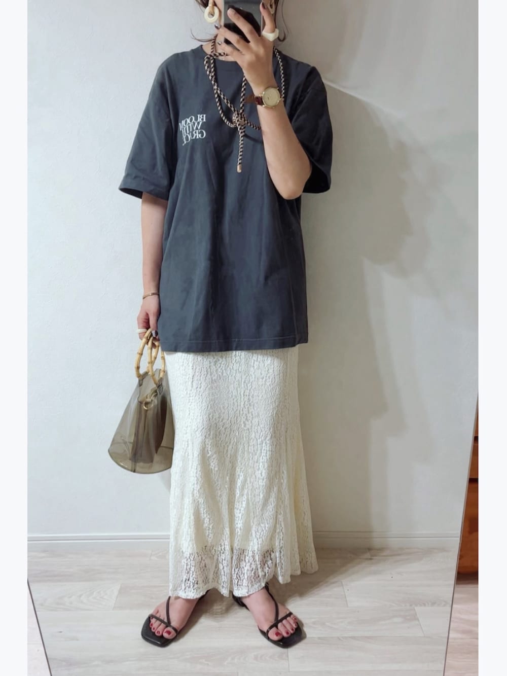 ブラック系のTシャツ/カットソー、ホワイト系のスカート、ブラック系のバッグを着用したレディースの夏コーディネートの3枚目の写真