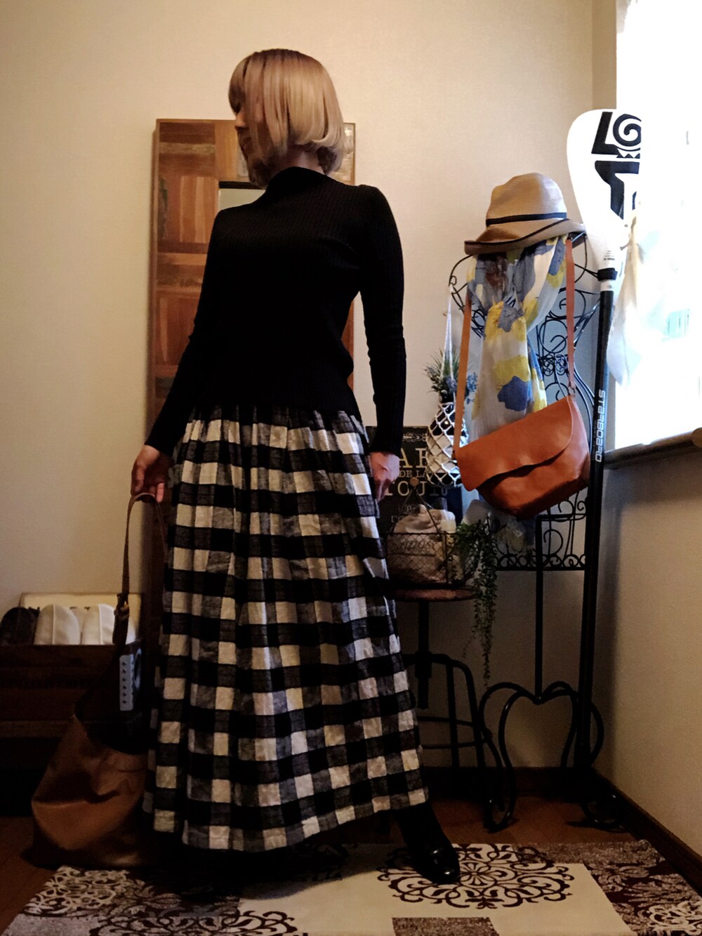 イエロー系のショルダーバッグ、ブラック系のニット/セーター、ブラック系のその他パンツを着用したレディースの春コーディネートの3枚目の写真