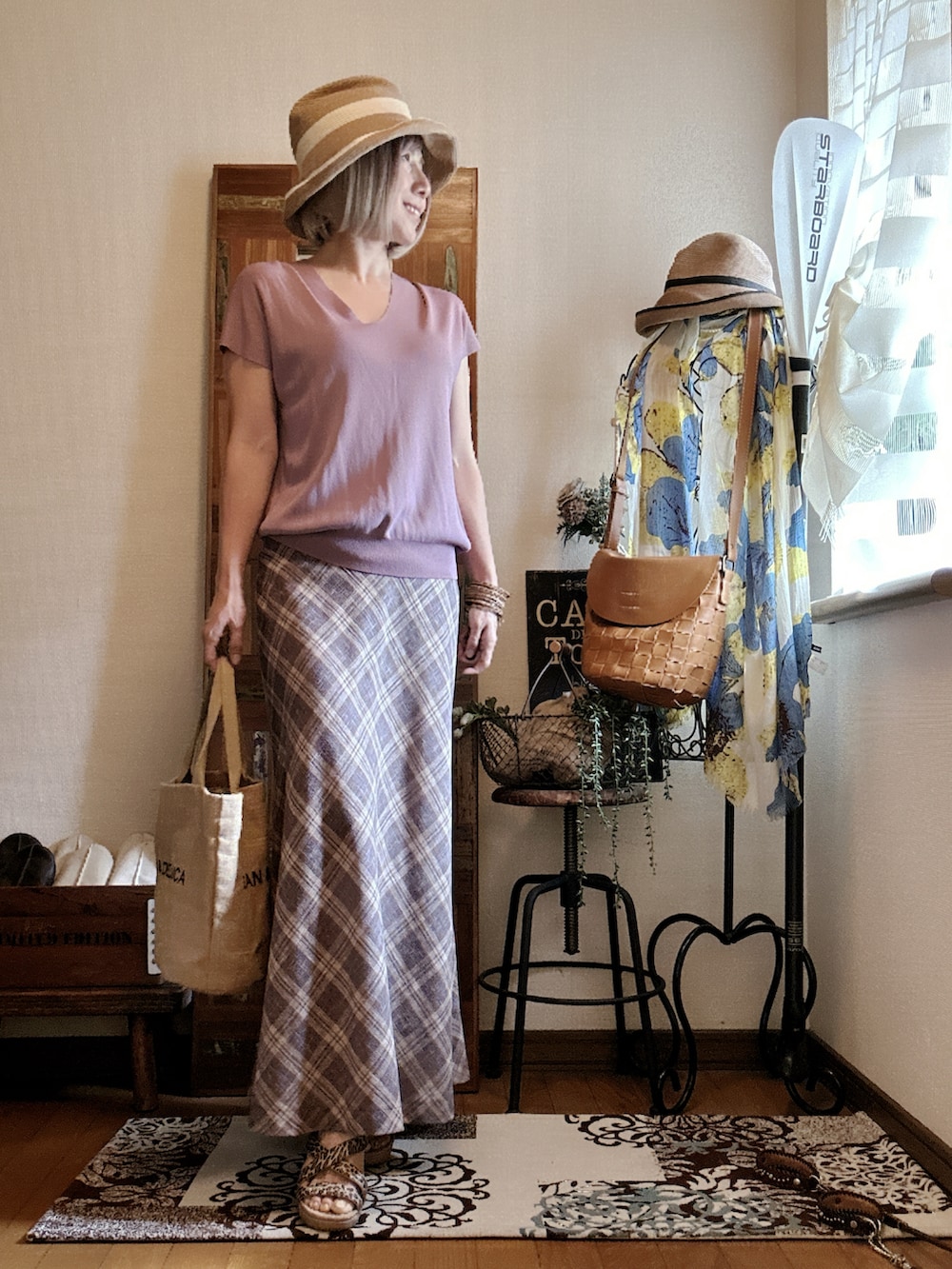 パープル系のニット/セーター、ベージュ系のスカート、ベージュ系のトートバッグを着用したレディースの夏コーディネートの2枚目の写真