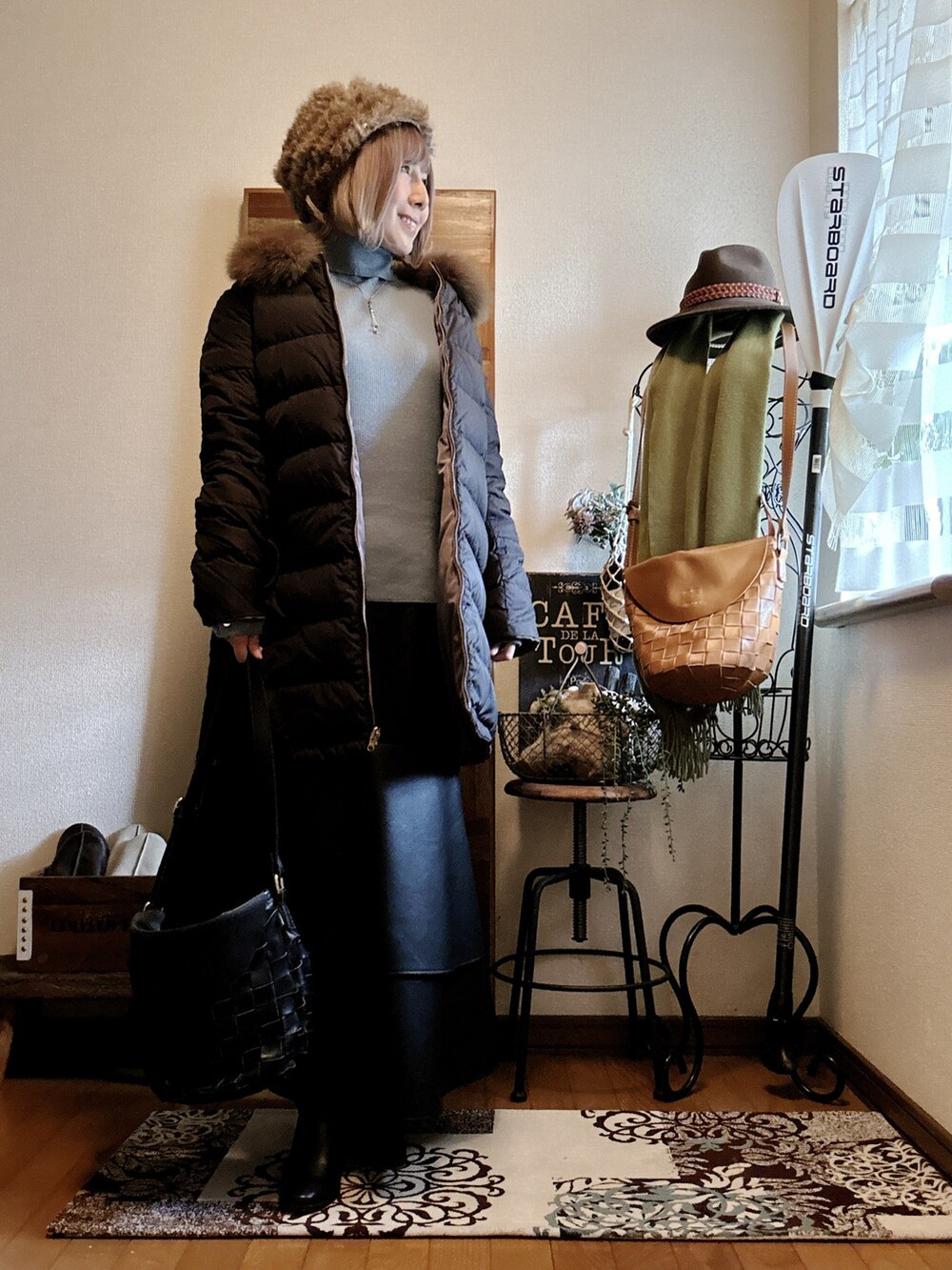 ブルー系のニット/セーター、ベージュ系のダウンジャケット/コート、ブラック系のショルダーバッグを着用したレディースの冬コーディネートの2枚目の写真