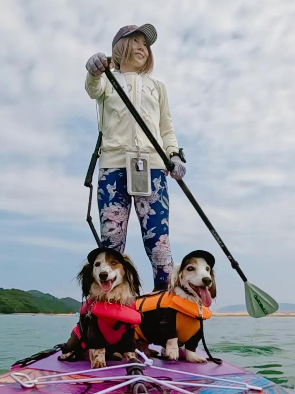 ブルー系のキャップ、ピンク系のウィッグ、ホワイト系のラッシュガードを着用したレディースの夏コーディネートの3枚目の写真