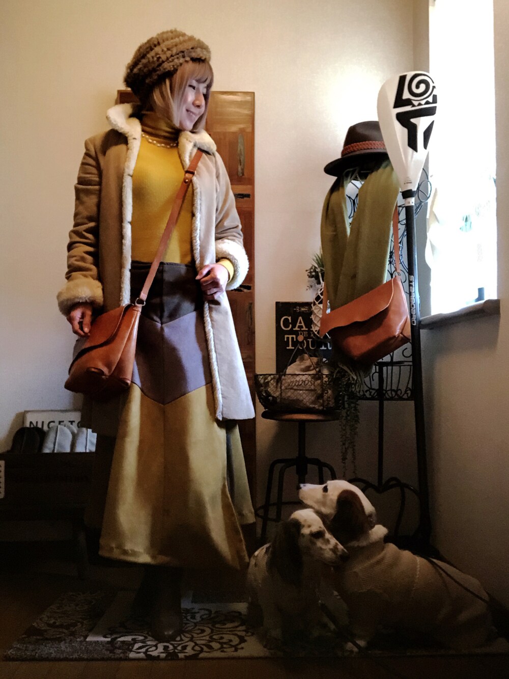 イエロー系のショルダーバッグ、ベージュ系のムートンコート、イエロー系のニット/セーターを着用したレディースの冬コーディネートの3枚目の写真