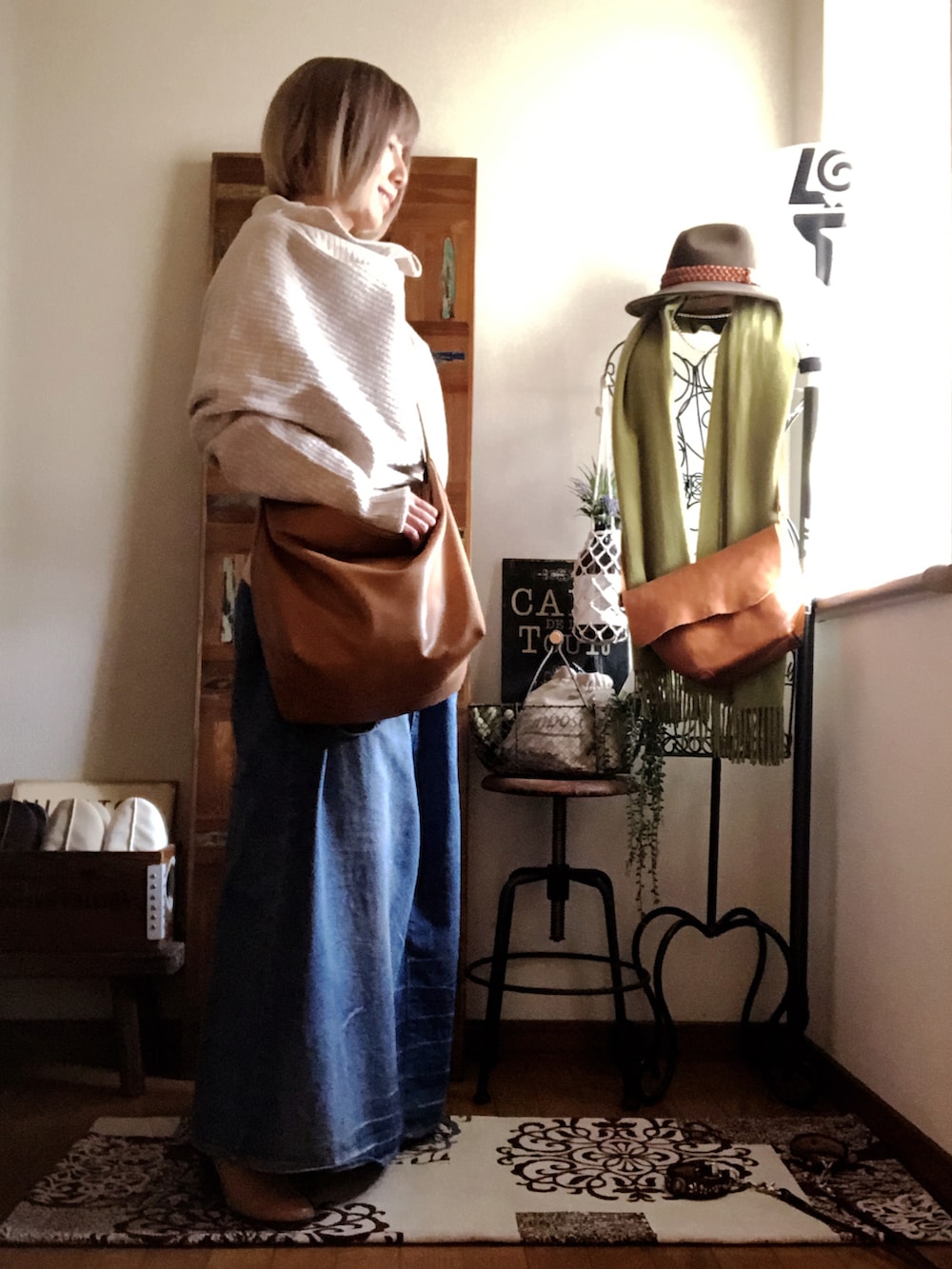 ベージュ系のニット/セーター、イエロー系のショルダーバッグ、ブルー系のデニムスカートを着用したレディースの春コーディネートの2枚目の写真