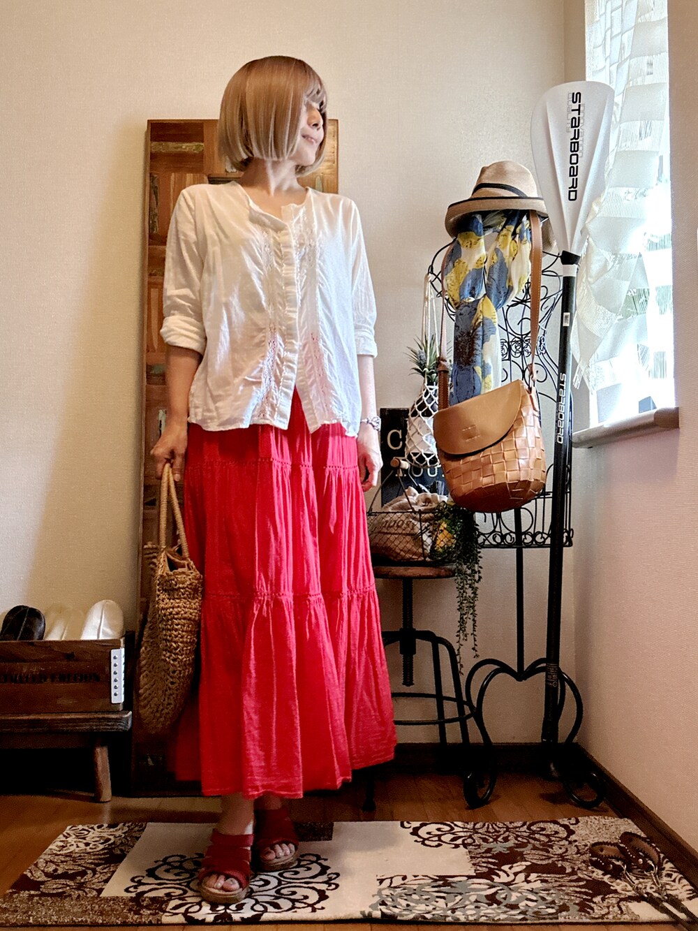 ベージュ系のかごバッグ、レッド系のスカート、ホワイト系のシャツ/ブラウスを着用したレディースの秋コーディネートの2枚目の写真