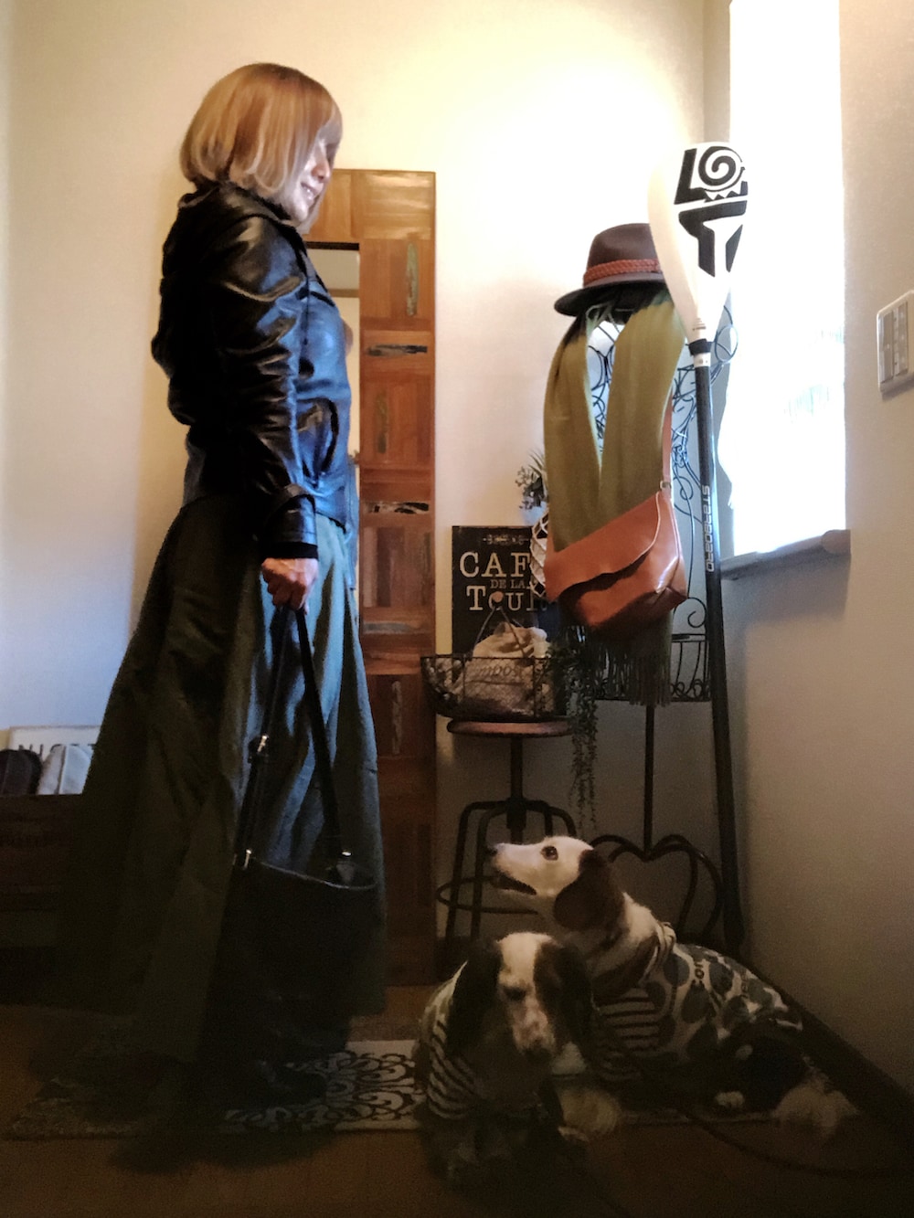 ブラック系のライダースジャケット、ブラック系のニット/セーター、グリーン系のスカートを着用したレディースの冬コーディネートの2枚目の写真