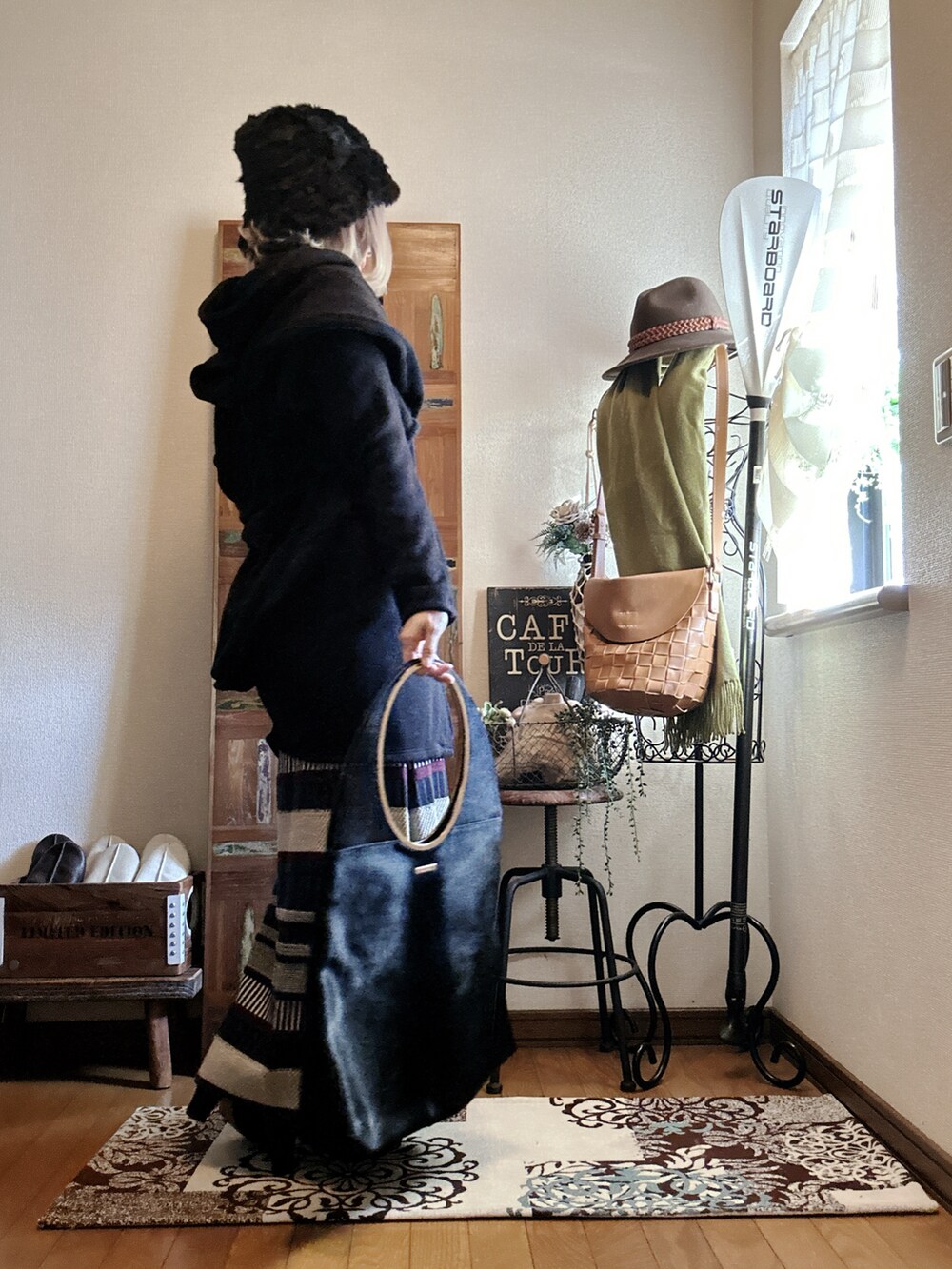 ブラック系のその他アウター、グリーン系のスカート、ブラック系のハンドバッグを着用したレディースの冬コーディネートの2枚目の写真