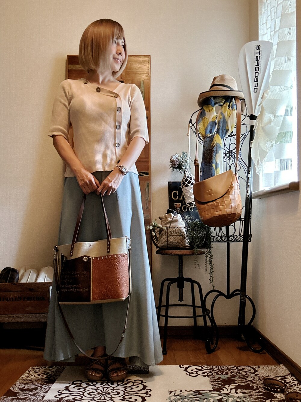 ホワイト系のニット/セーター、ブラウン系のショルダーバッグ、グリーン系のスカートを着用したレディースの秋コーディネートの3枚目の写真