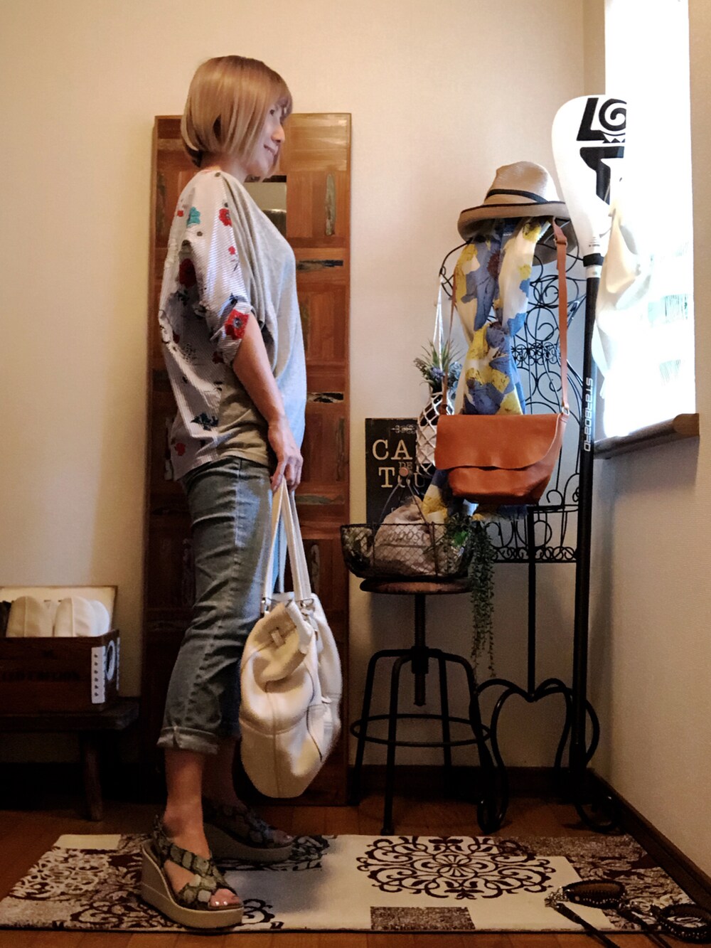 ホワイト系のバッグ、グレー系のTシャツ/カットソー、ブルー系のデニムパンツを着用したレディースの夏コーディネートの3枚目の写真